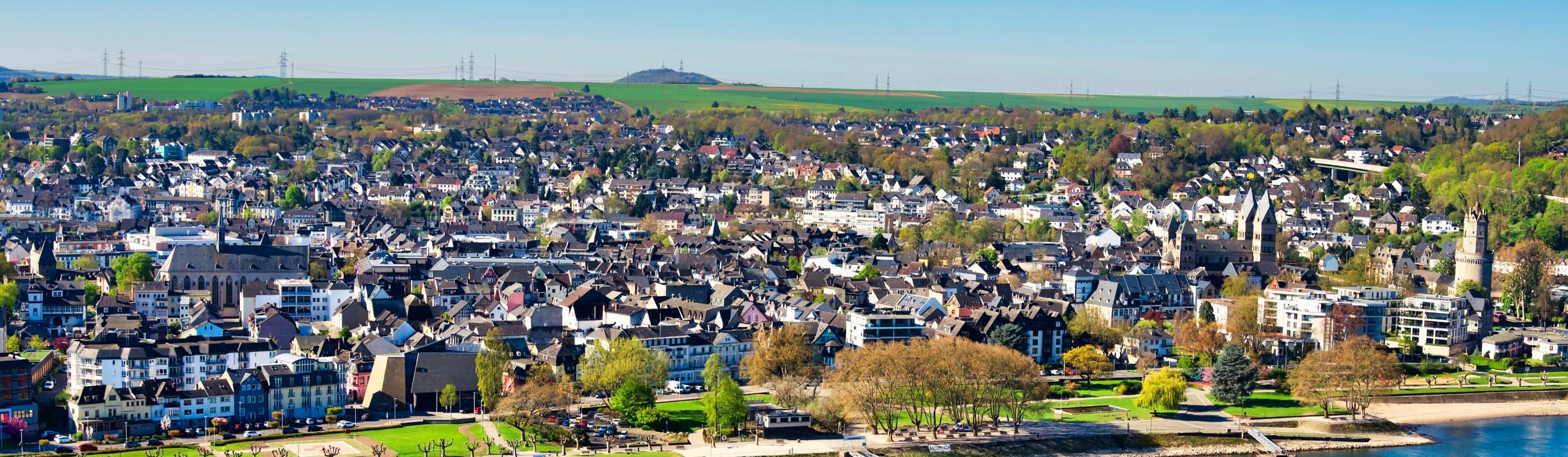 Blick auf die Pfarrei St. Marien. Im Vordergrund ist ein Fluss und die Uferpromenade zu sehen.
