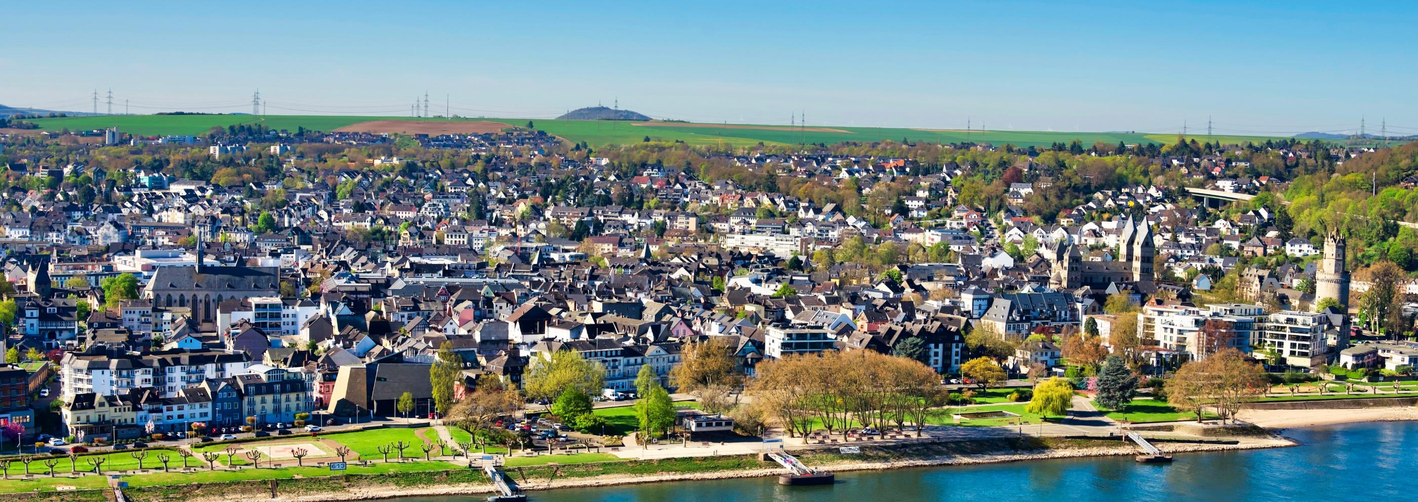 Blick auf die Pfarrei St. Marien. Im Vordergrund ist ein Fluss und die Uferpromenade zu sehen.