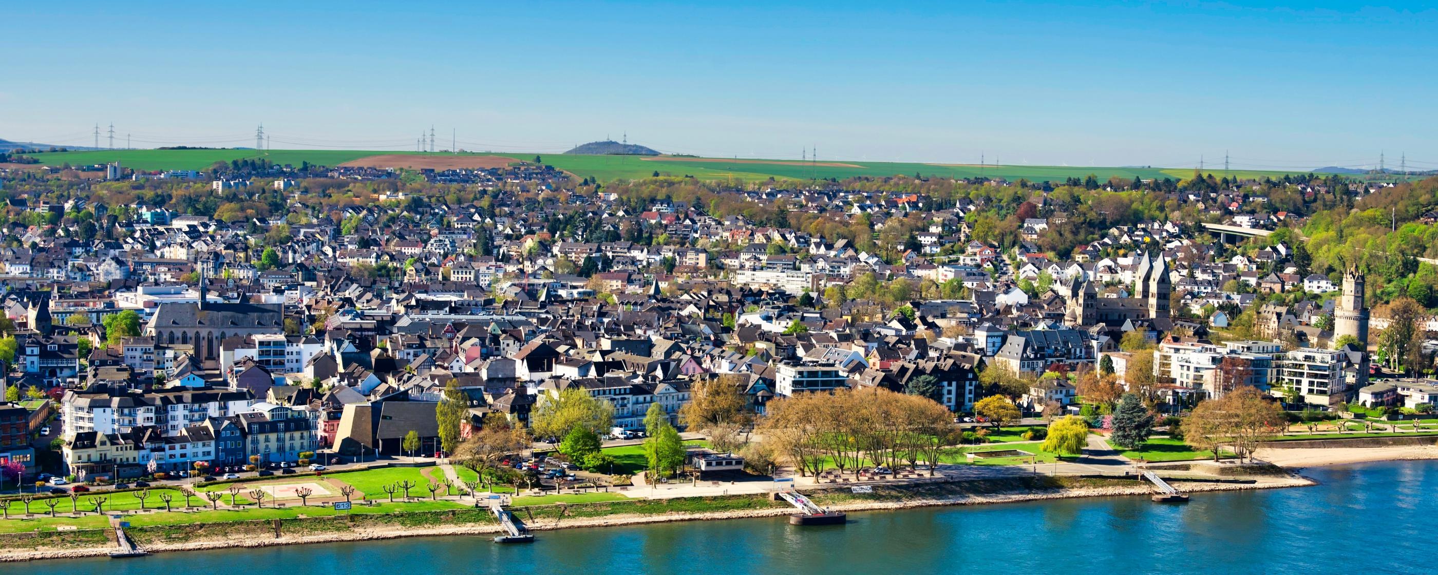 Blick auf die Pfarrei St. Marien. Im Vordergrund ist ein Fluss und die Uferpromenade zu sehen.
