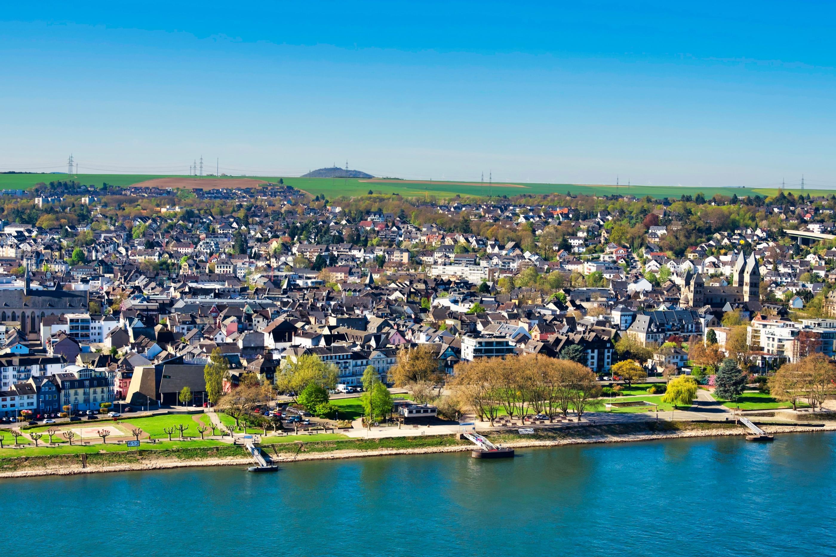 Blick auf die Pfarrei St. Marien. Im Vordergrund ist ein Fluss und die Uferpromenade zu sehen.