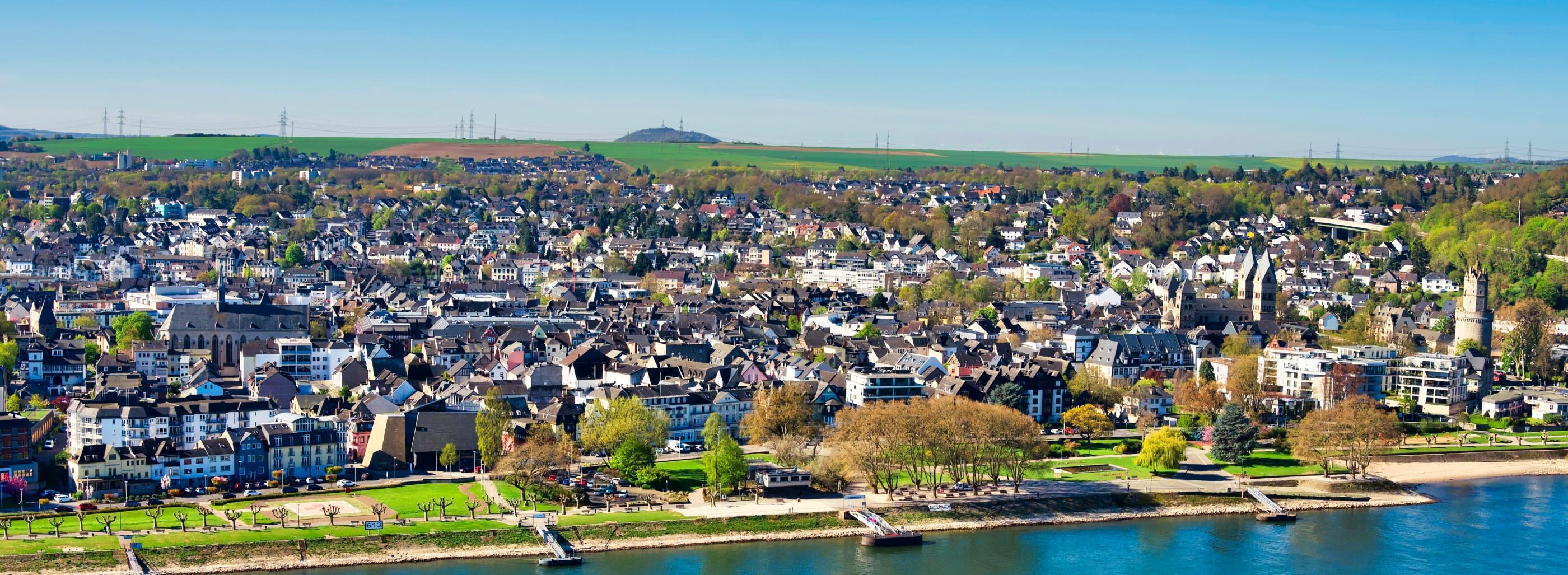 Blick auf die Pfarrei St. Marien. Im Vordergrund ist ein Fluss und die Uferpromenade zu sehen.